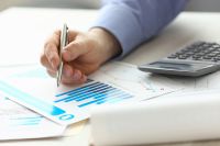 Foto: Person zeigt mit Stift auf Akten